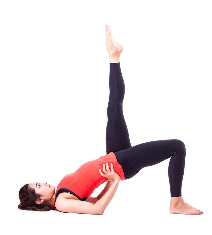 Physiotherapie-Übung in Brückenposition mit gehobenem Bein